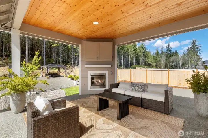Relax year-round on the covered patio, gas fireplace glowing, a sense of privacy all around, and a space designed for comfortable, effortless outdoor living.
