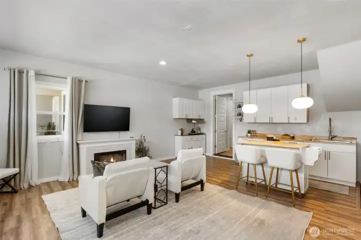 Another view of the versatile additional living space, showcasing the kitchenette and fireplace, perfect for entertaining, relaxing, or creating a comfortable extended living area.