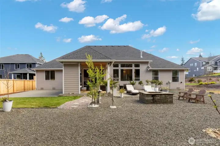 Dual extended uncovered patios offer multiple outdoor living zones, perfect for lounging, dining, and gathering around the firepit, all set within a beautifully landscaped and private backyard.