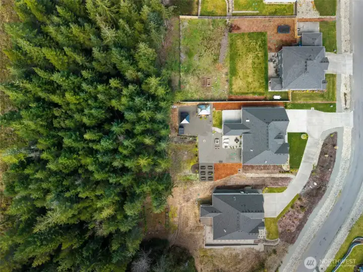 Aerial view showcasing expansive outdoor living on a shy acre, thoughtfully designed spaces surrounded by natural beauty, offering both privacy and room to breathe.
