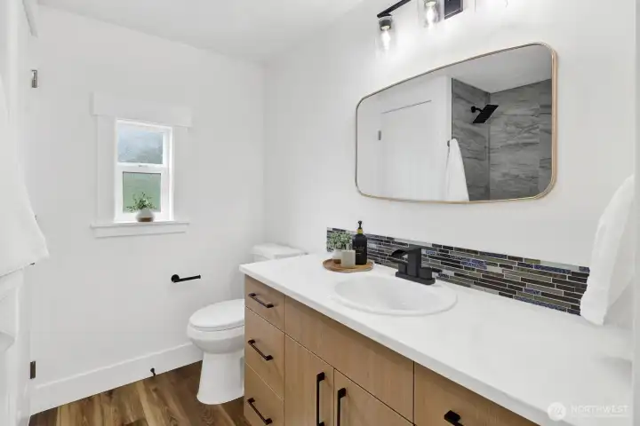 Renovated en-suite bathroom showcasing a new tub, updated vanity and sink, ample cabinetry, and contemporary finishes. Renovated en-suite bathroom showcasing a new tub, updated vanity and sink, ample cabinetry, and contemporary finishes.
