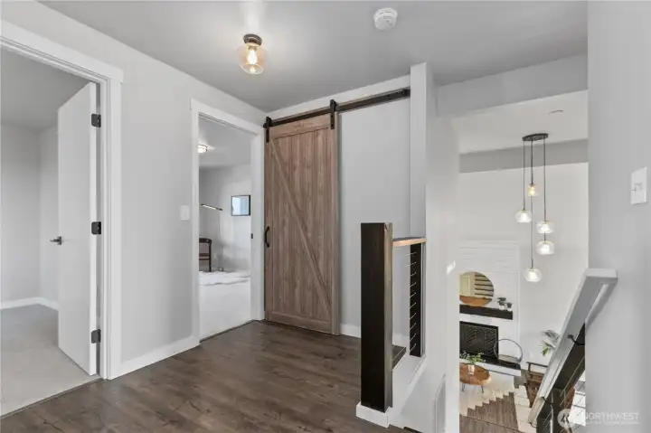 Upper-level landing features durable flooring, modern cable railing, and barn door accents that add character and architectural interest. Upper-level landing features durable flooring, modern cable railing, and barn door accents that add character and architectural interest.