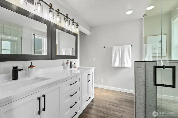 Luxurious ensuite bath includes dual vanities, oversized walk-in closet access, and a custom tiled shower with upscale finishes throughout. Luxurious ensuite bath includes dual vanities, oversized walk-in closet access, and a custom tiled shower with upscale finishes throughout.
