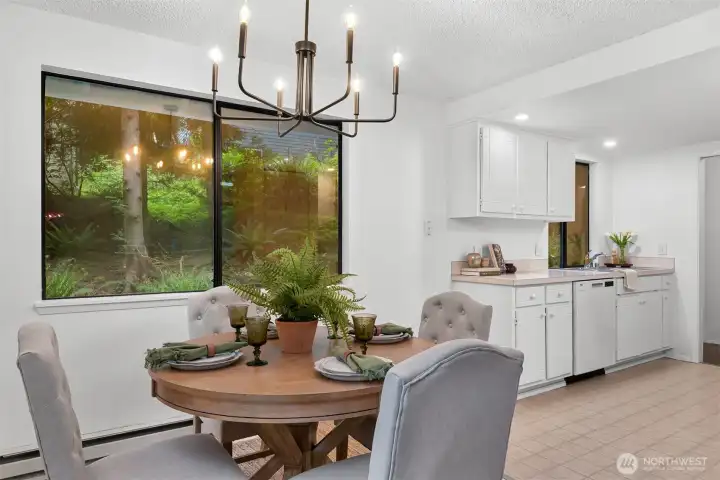 Dining area is surrounded by tall windows and natural views, creating a peaceful setting for meals and gatherings.