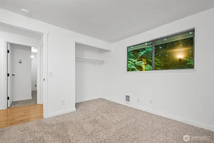 Third bedroom offers comfortable space, and peaceful wooded views outside the window.