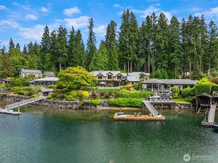 The curvature of the shoreline is mirrored by the home allowing breathtaking water views across the stone, covered patio, lawn and gardens.
