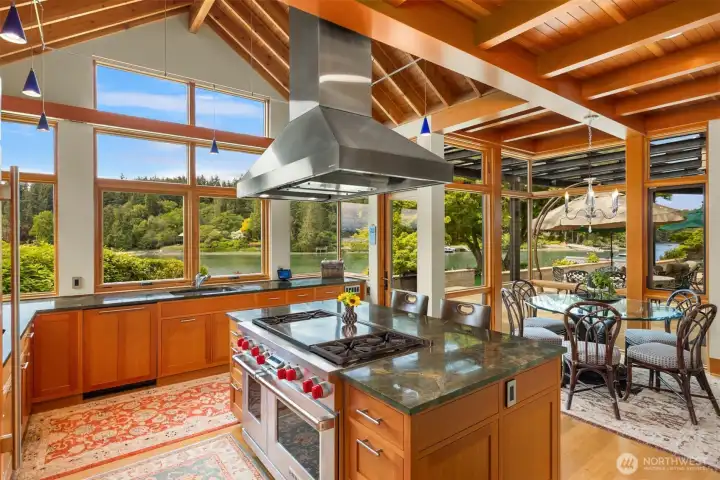 Kitchen with rich granite counters, cherry cabinets, views to the covered patio and water.