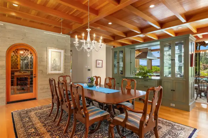 View to the wine cellar set in a curved cement wall extending the exterior curvature of the home to the interior space.