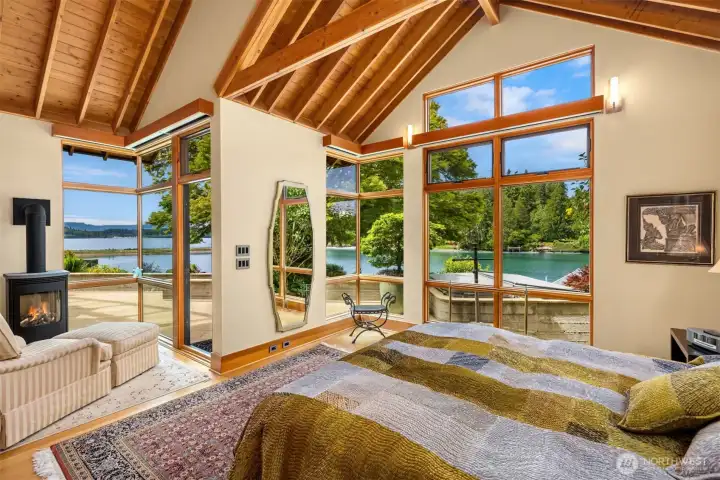 The waterside primary suite. Cornered floor-to-ceiling windows, exposed wood - vaulted ceiling all framing the Olympic Mountains and ever changing tidal bay.
