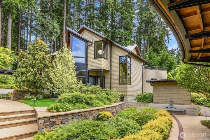 View from the front door across the gardens to the 1,297 square foot, finished/heated 3 car garage and upper guest suite. The greenhouse is to the right.