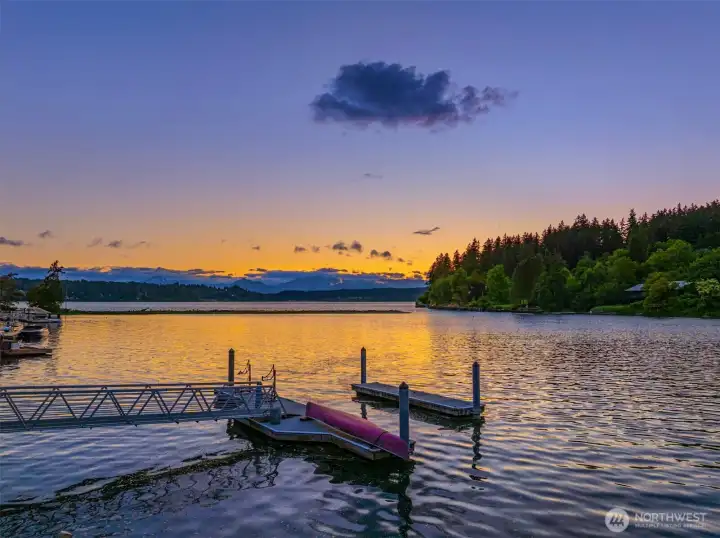 The home's private floating dock with the distant Olympic Mountains at sunset.
