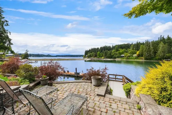 110' of private shoreline accessible from two points, this stairway to the top of the bulkhead and the dock. The Paleo stone patio is set into calming, beautifully curated gardens.