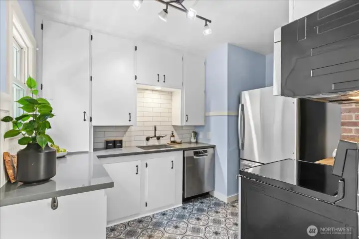 Modern kitchen with stainless steel appliances and quartz counters.
