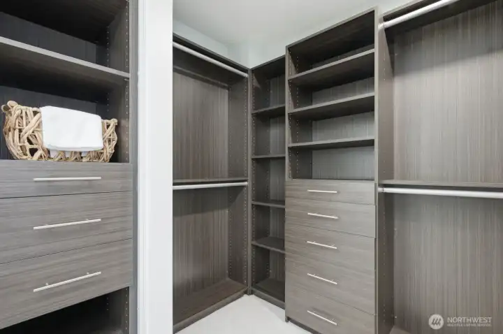 Primary walk-in closet with custom organization system. Primary walk-in closet with custom organization system.
