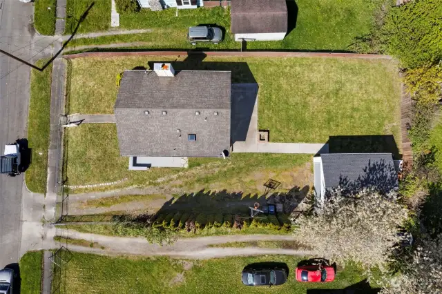 Aerial view of the home, garage, and property, which is entirely fenced.