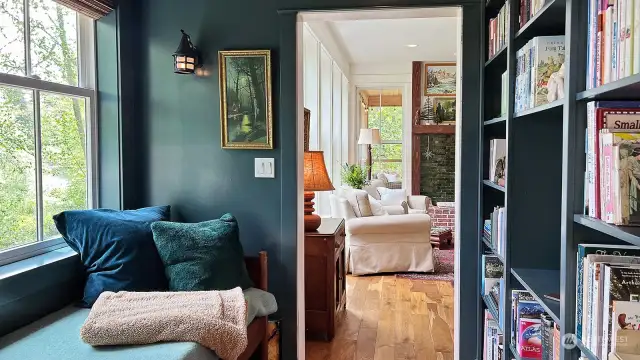 The rich deep color tones adds to the sense of warmth and comfort that is woven throughout this home. This sweet reading nook is the perfect place to curl up with a cup of tea and your favorite book. Follow the oak floors into the living room.