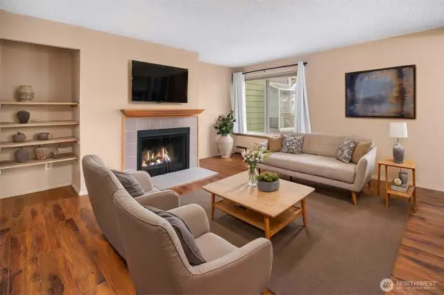 Spacious 660 sq ft interior with a bright living room featuring a large window overlooking the peaceful courtyard. Built-in shelves offer stylish and functional extra storage—perfect for books, décor, or media.