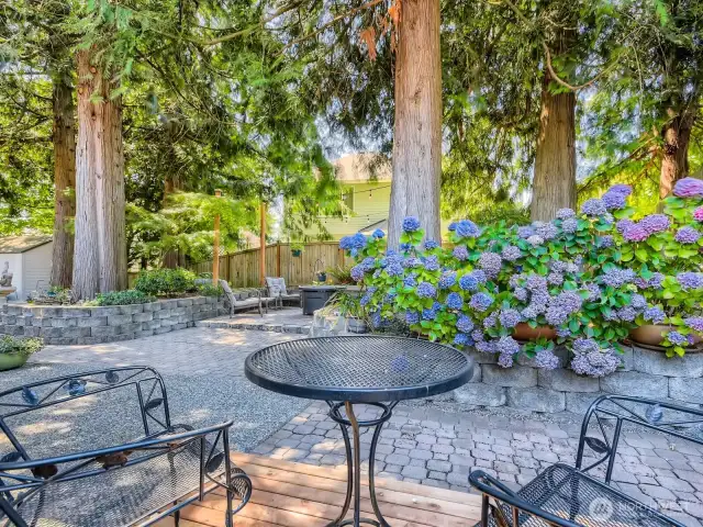 CUSTOM PAVER BACKYARD PATIO DECK WITH LOVELY LANDSCAPING AND ROOM FOR RAISED BED GARDENS.