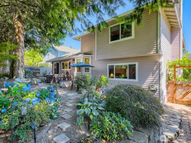 CHARMING TRAILS AND FLORAL SURPRISES THROUGHOUT THE BACK YARD.
