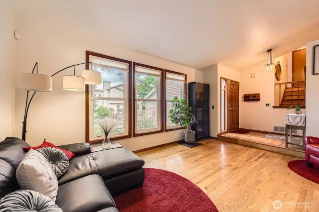 WELCOMING LIVING ROOM HAS PLENTY OF SPACE FOR FURNITURE, AND ABUNDANT NATURAL LIGHT.