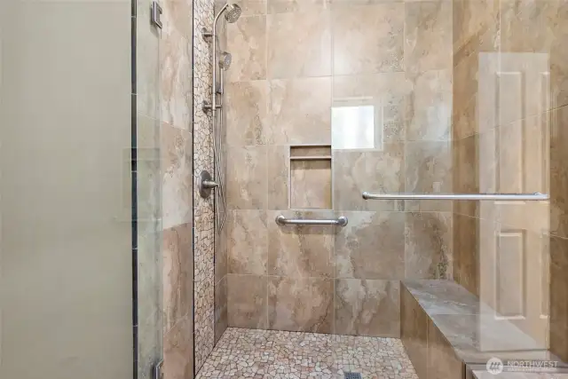 Large tiled shower in primary bathroom.