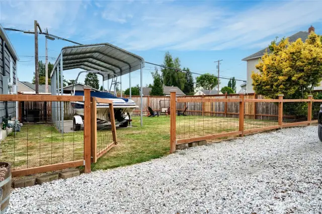 View of fully fenced in back yard with canopy parking