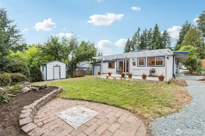 Refreshed backyard with custom brick patio, water feature and raised flower beds.