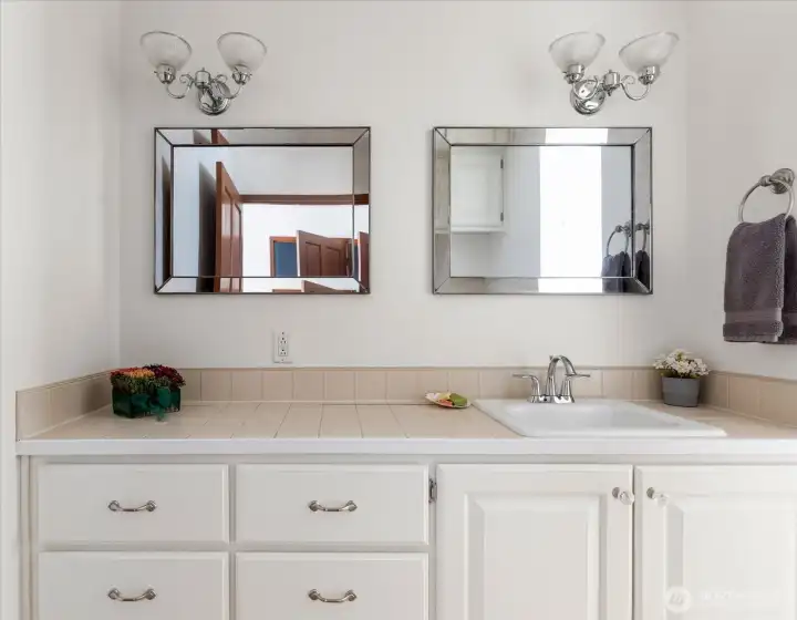 Spacious counter and double mirrors in primary bathroom