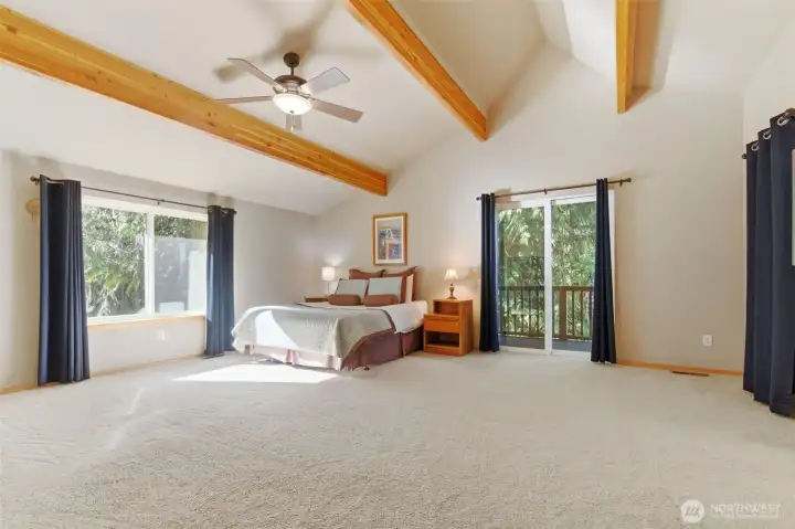 Primary bedroom on upper level creates a retreat tucked beneath angled ceilings, creating warmth and character.