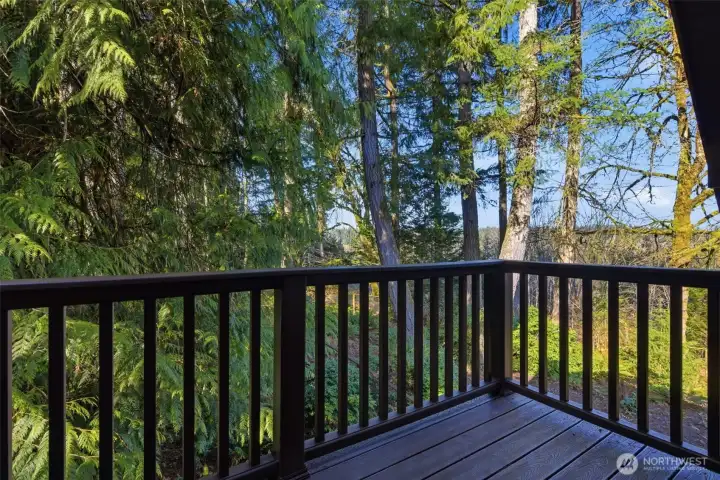 Private deck off the primary bedroom features a peaceful view of the grounds below.