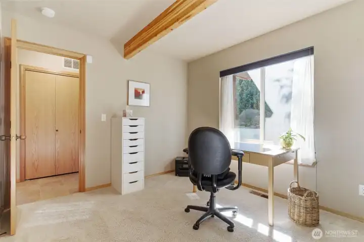 A flexible main-floor room serves beautifully as either a bedroom or a den, designed with comfort and versatility in mind. The space feels warm and grounded, and reflects natural light from a generously sized window.