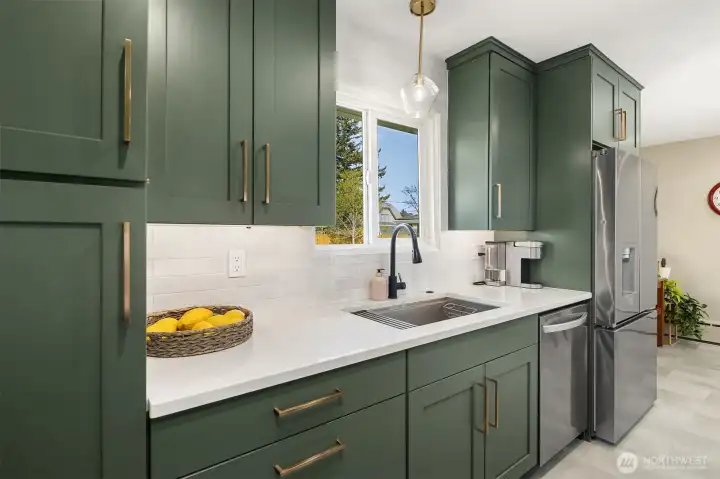 Quartz counters and a stainless farmhouse sink in the kitchen with built in garbage disposal.