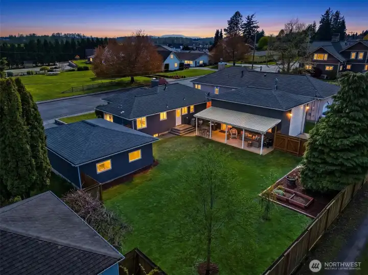 Aerial view of the back of the home by twilight.