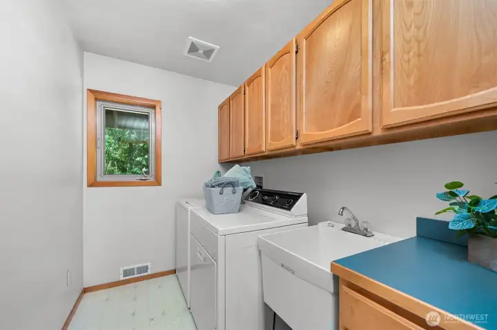 laundry room includes a convenient sink and lots of storage