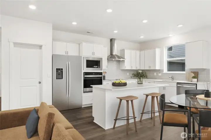 The heart of the home has an island kitchen, slab quartz countertops, full height tile backsplash, soft close cabinets, and plenty of light.  Picture for representational purposes only, colors and features may vary.