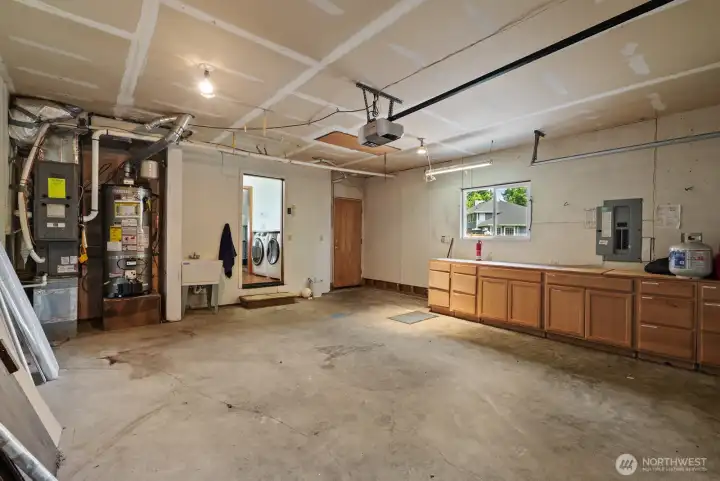 Spacious garage with work bench and cabinets