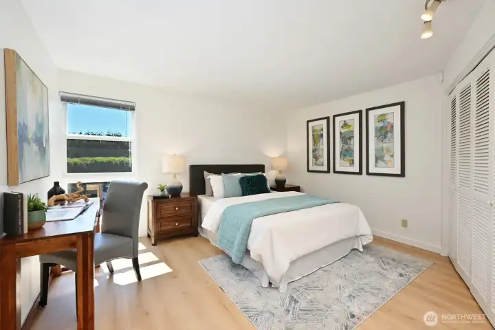 Bright and expansive primary bedroom with space for a desk or sitting area, designed for both relaxation and functionality.