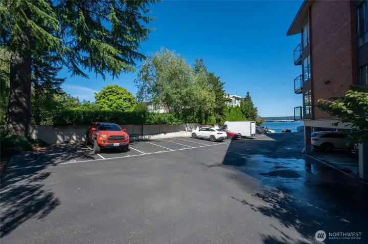 Designated parking in a private gated lot alongside a resident lake access point with stairs for swimming, paddle boarding, kayaking, or cold plunges.