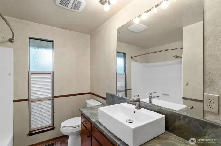 Primary bath with updated counter top and sink.