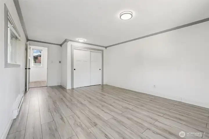 Spacious primary bedroom at 4612 N 21st St, Tacoma, WA — virtually staged to showcase its generous layout, wide-plank flooring, large windows with natural light, and flexible space for a sitting area or home office. This North Tacoma retreat offers comfort, privacy, and room to personalize with modern finishes throughout.