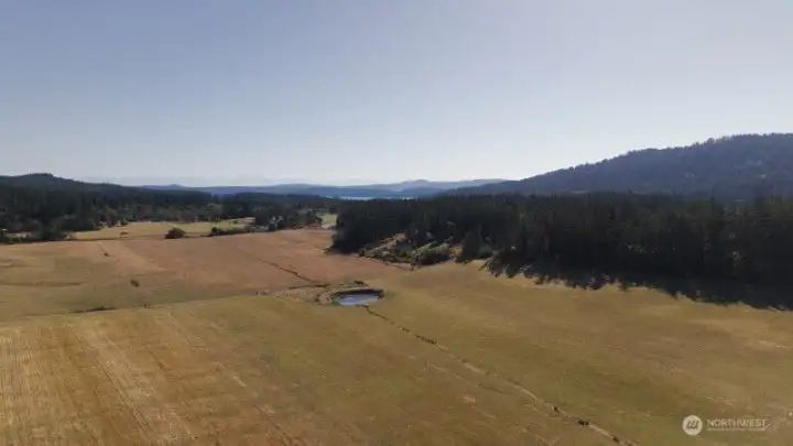 Looking South, Southwest across East Crow Valley. The property is tucked into the tree line just south of the pond.