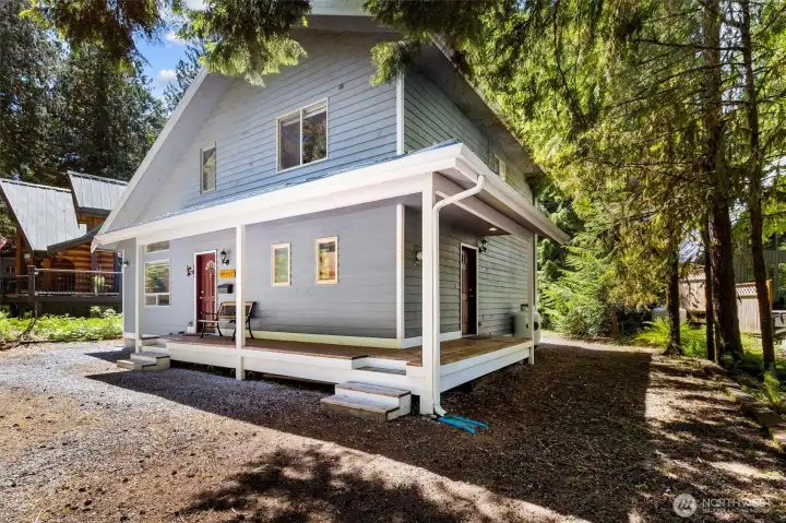 Side exterior view showing cabin-style charm and wooded privacy.