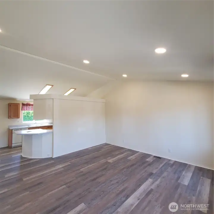 Living room and kitchen with vaulted ceilings and new can liting with dimmer and new flooring thru out the house.