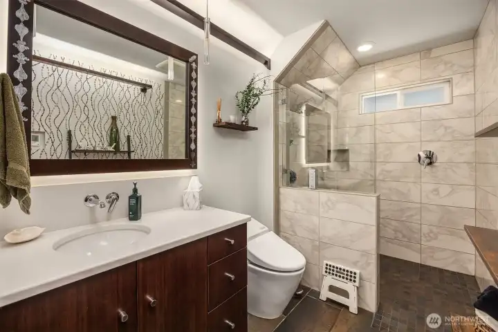A wonderful three-quarter bath on the main level offers a zero-entry shower with stylish custom tile from floor to ceiling.