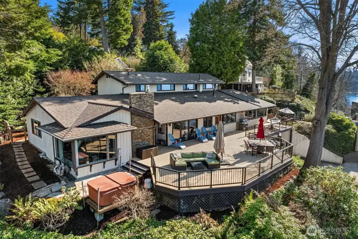 The back of the home opens to a massive entertaining deck overlooking the breathtaking waters of the Puget Sound, surrounded by lush, landscaped grounds for a true private retreat.