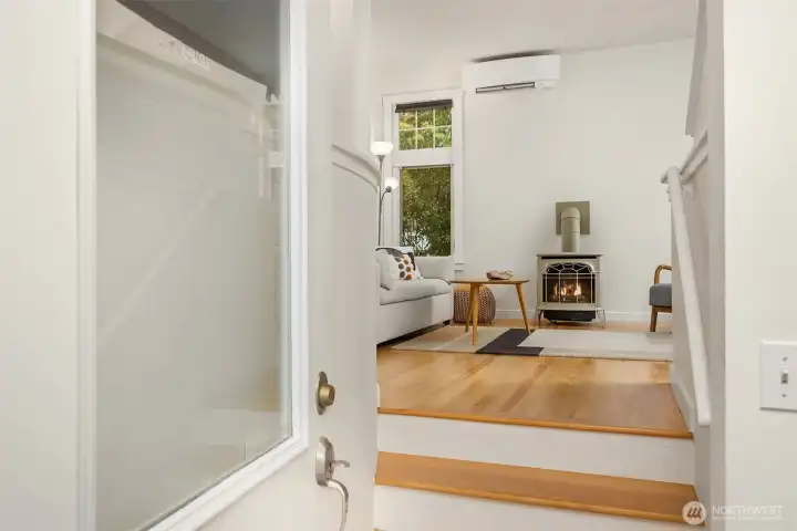 The front door opens into a welcoming space featuring hardwood floors and a cozy propane fireplace.