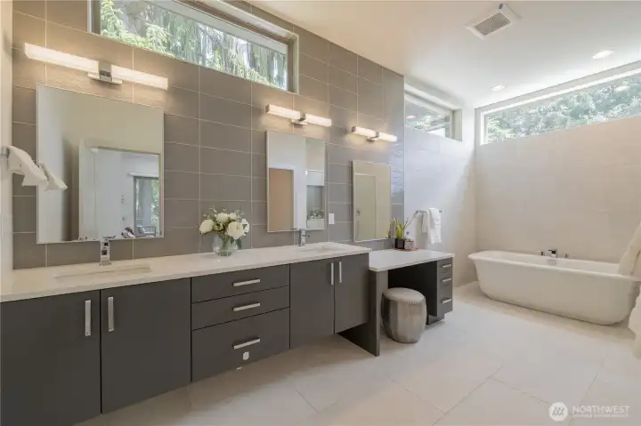 Spa-like bathroom with double sinks, vanity, heated floors, large tub and walk-in shower.