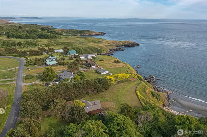 Panoramic aerial captures the dramatic shoreline, surrounding island landscape, and expansive marine views toward Haro Strait and the Olympic Mountains.