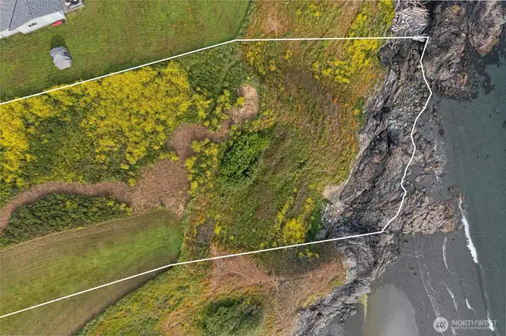 Aerial boundary view shows the property extending toward the rocky bluff and coastal edge, offering a rare San Juan Island waterfront land opportunity.
