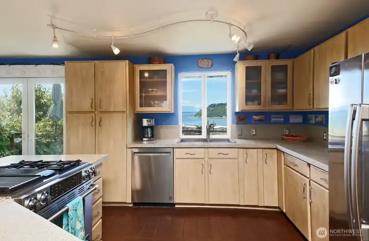Kitchen window captures the water view. The stainless steel appliances include a new dishwasher (2025).